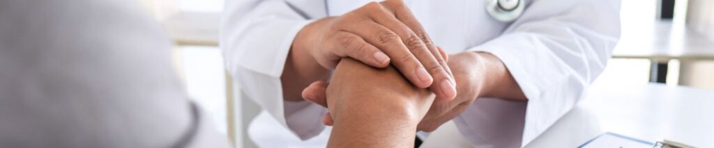 Doctor Supporting Patient By Holding Hand