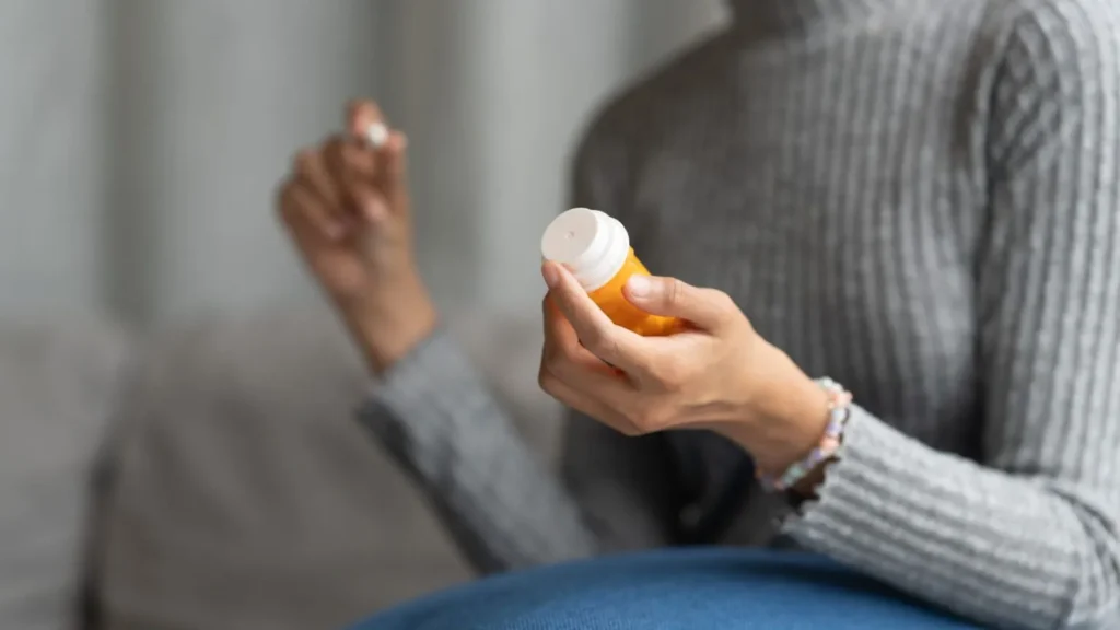 Person Holding Prescription Bottle In Hand