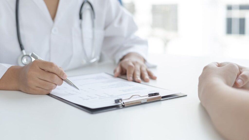 Doctor Writing Prescription During Patient Consultation