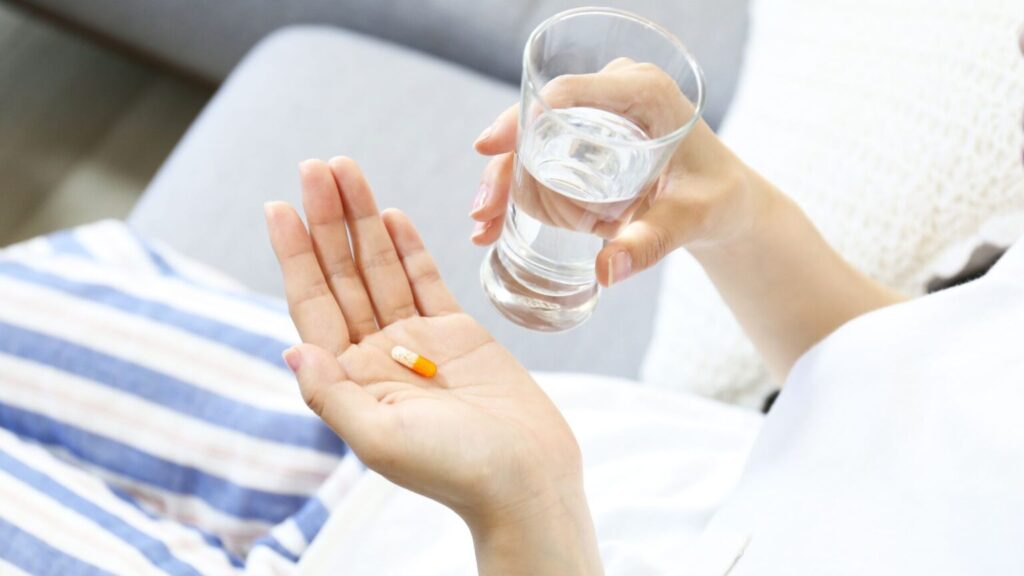 Person Taking Medicine With Water