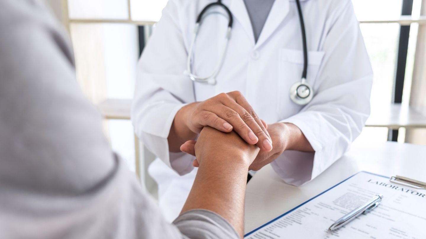 Physician listening supportively to a patient during a consultation